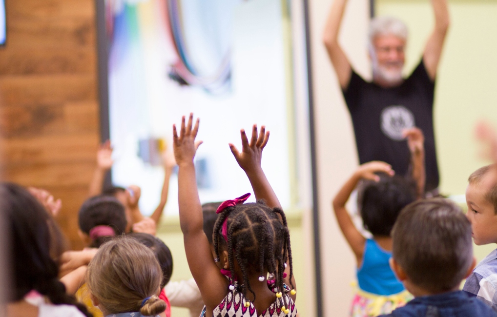 Children in a class raising hands