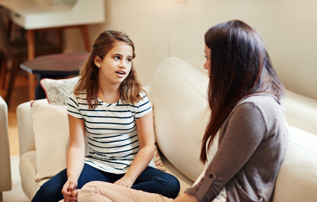 Mother talking to their child on a sofa