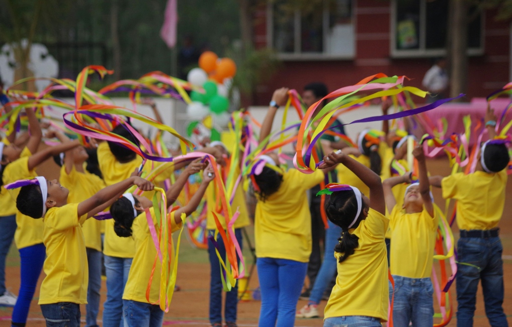Children outside playing with ribbons