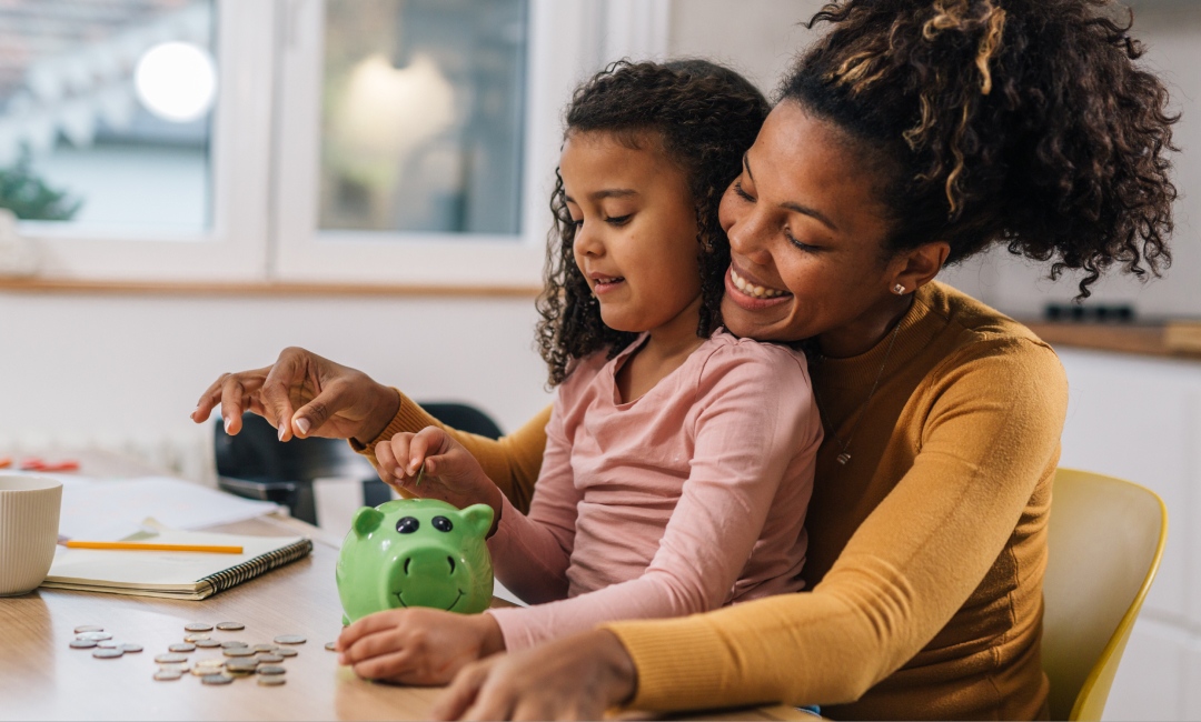 Mother and Child putting money in a piggy bank