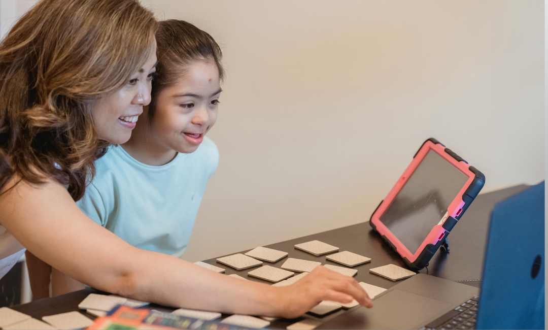 Child learning about investing with a tablet and laptop