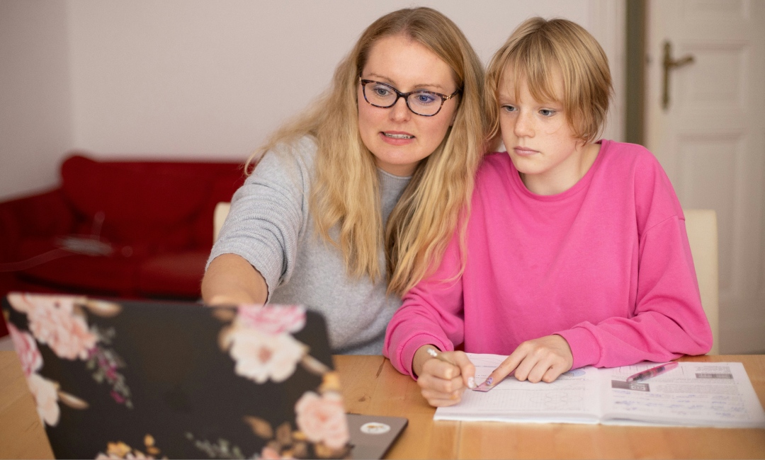 Mother teaching daughter about debt management with a laptop