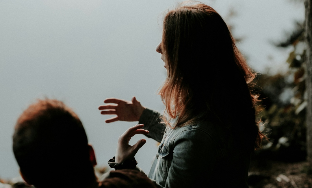 Woman gesticulating whilst talking to another person