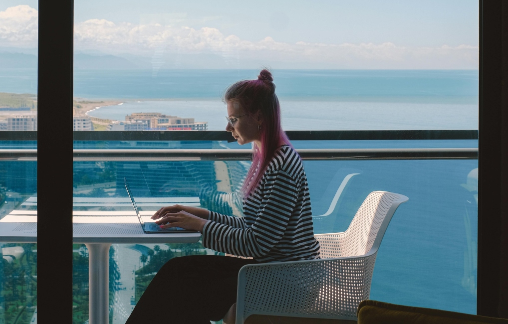 Woman working remotely in a building high up by the sea