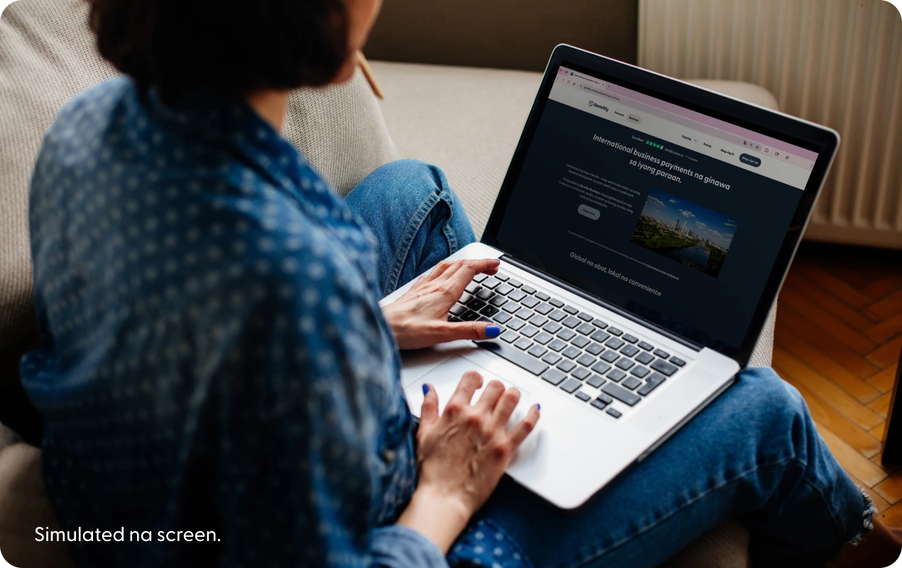 Isang taong gumagamit ng laptop na nagpapakita ng isang na-simulate na landing page ng Remitly business.