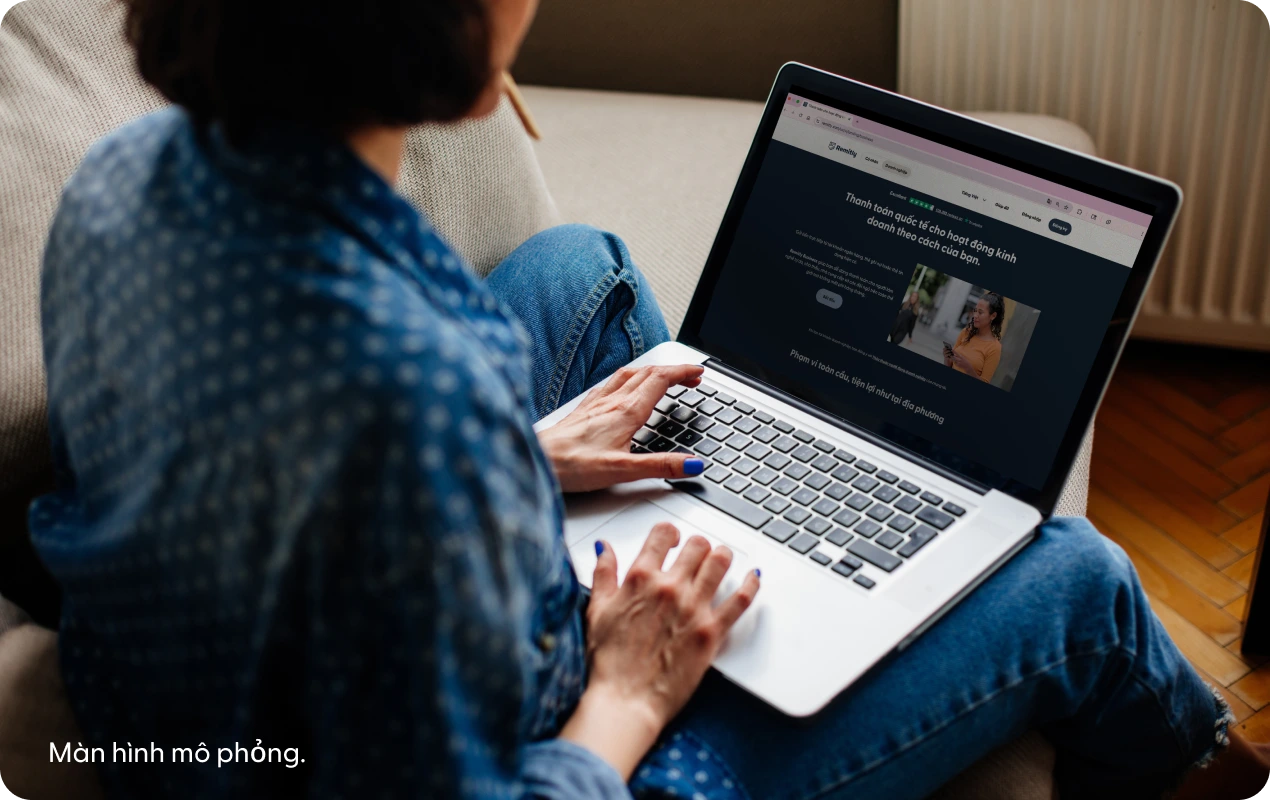 Một người đang sử dụng máy tính xách tay để xem trang đích giả lập của Remitly Business.